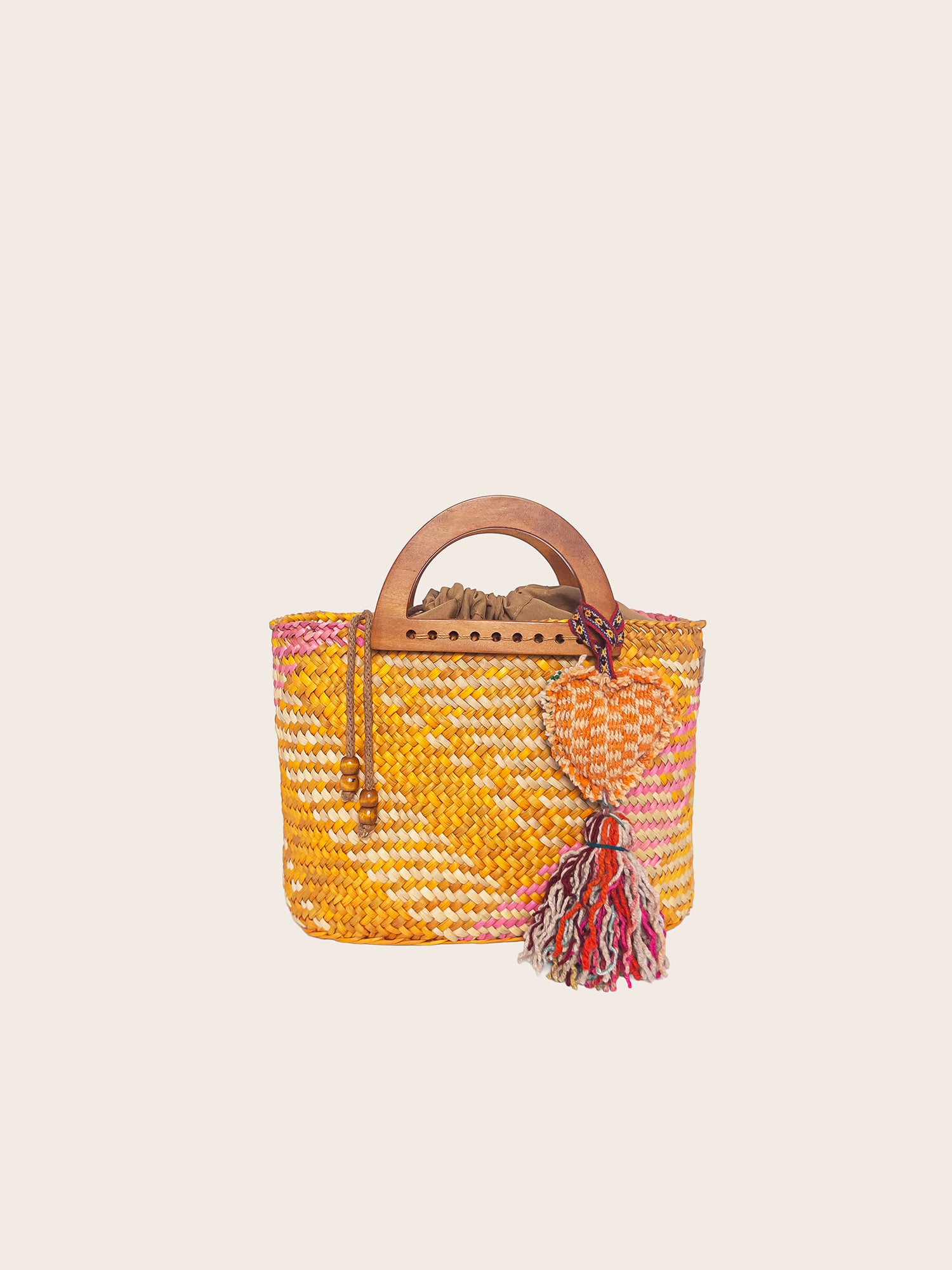 The Sophia bag in washed yellow and pink, handwoven with wooden handles and a colorful tassel.