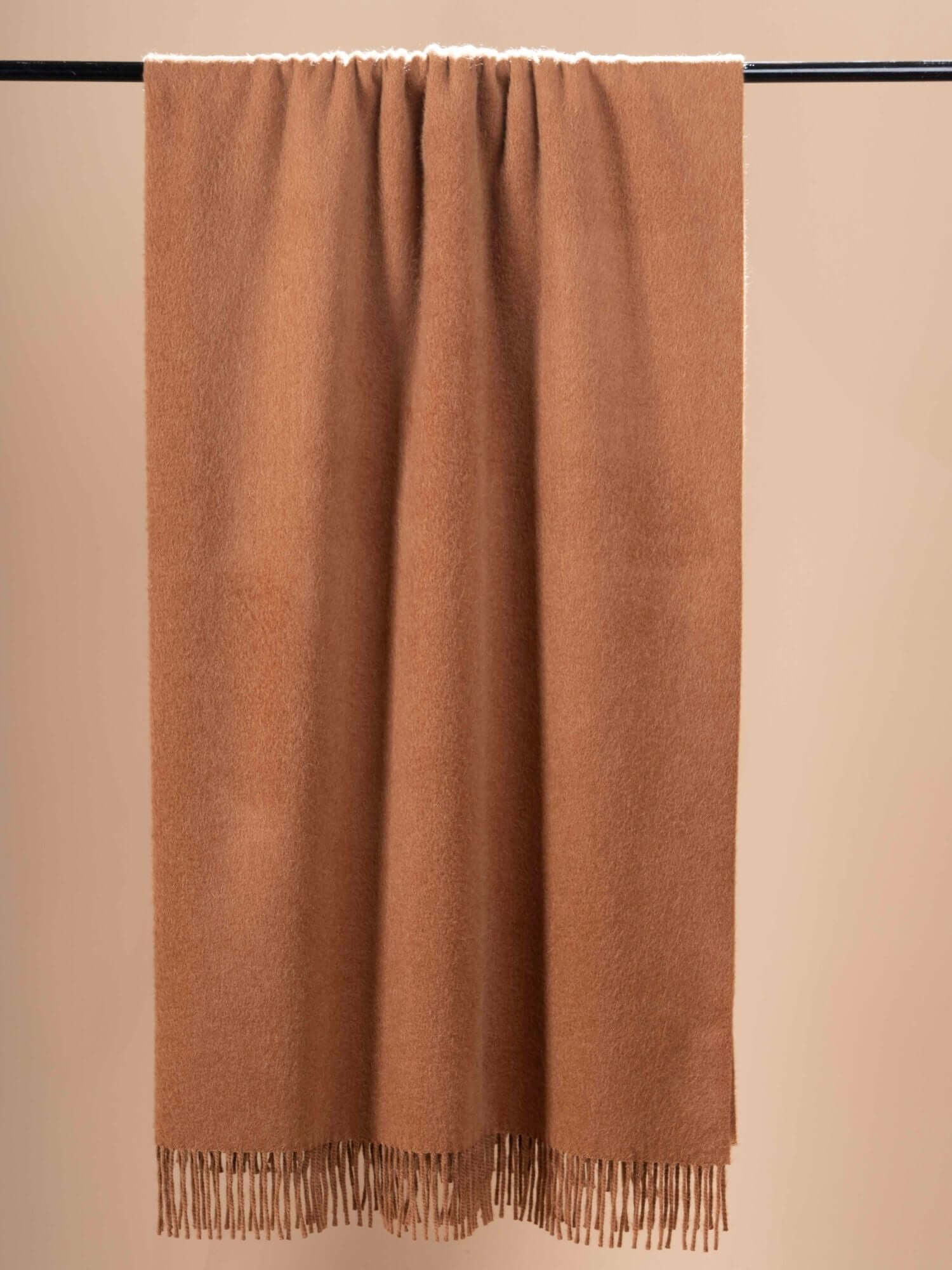 Super Wash Throw in camel color, made from baby alpaca and wool blend, featuring hand-twisted fringe edges.