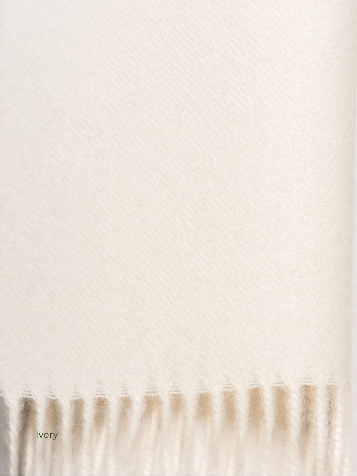 Ivory undyed baby alpaca scarf, close-up of the soft cream fabric and fringe