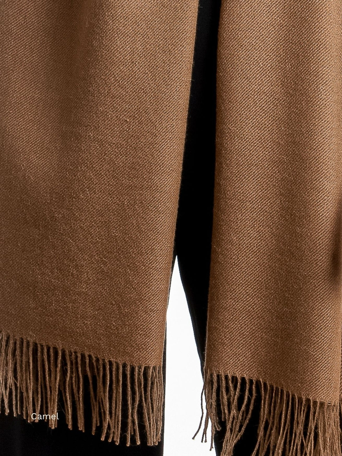 Camel undyed baby alpaca shawl hanging full length over black trousers, fringe at both ends