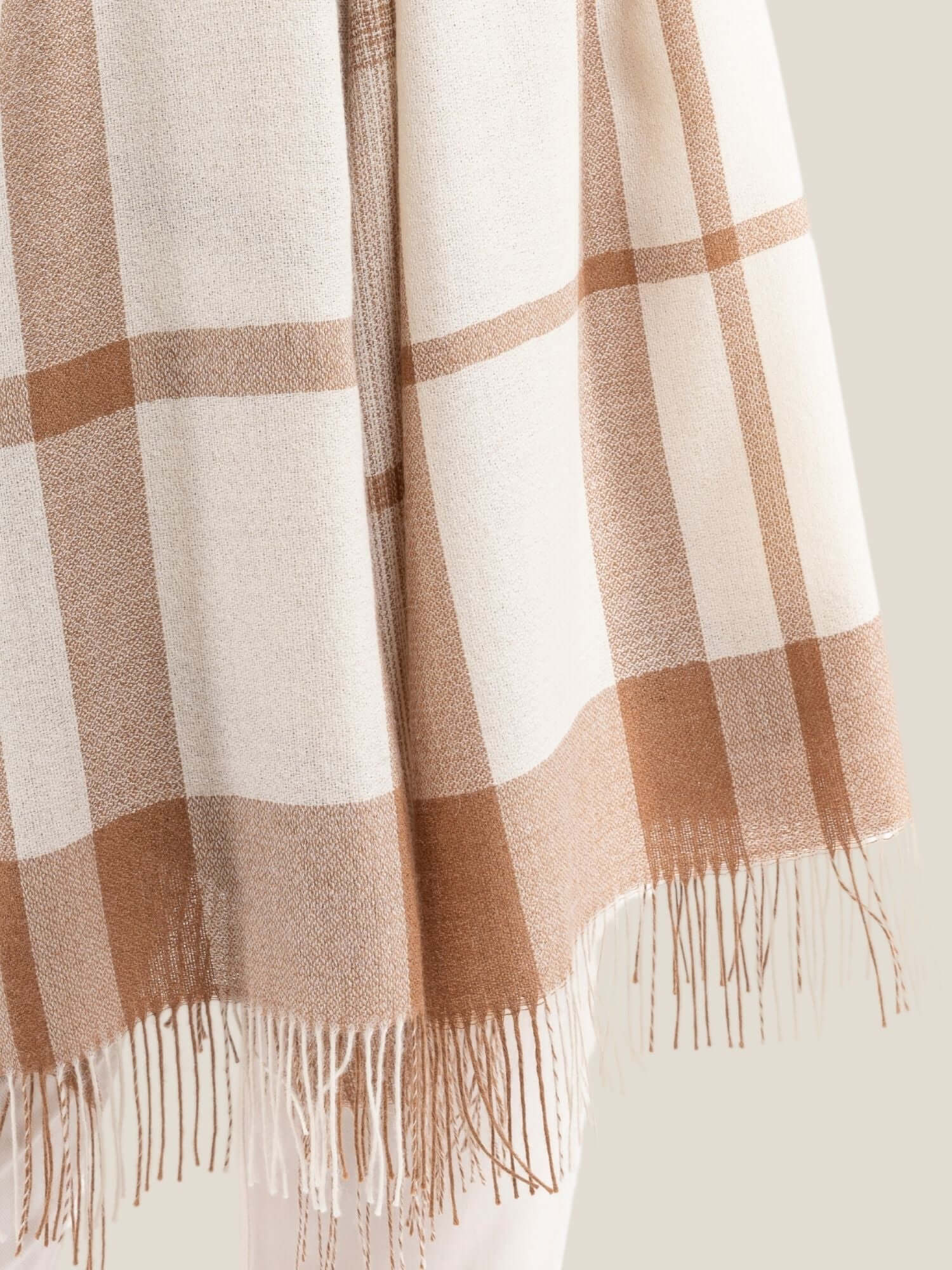 Close-up of soft alpaca wool shawl showing luxurious light fibre texture in white and camel brown