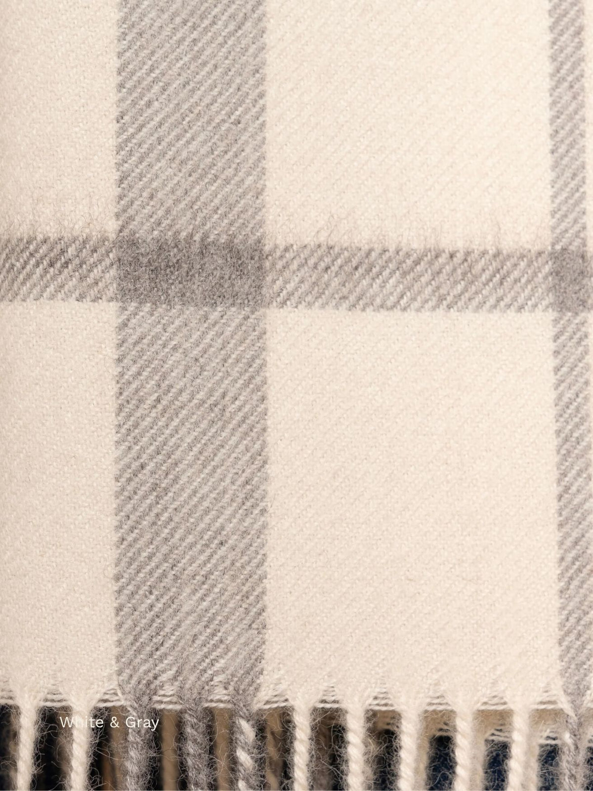 White and grey plaid baby alpaca scarf, close-up of the grey check pattern and fringe