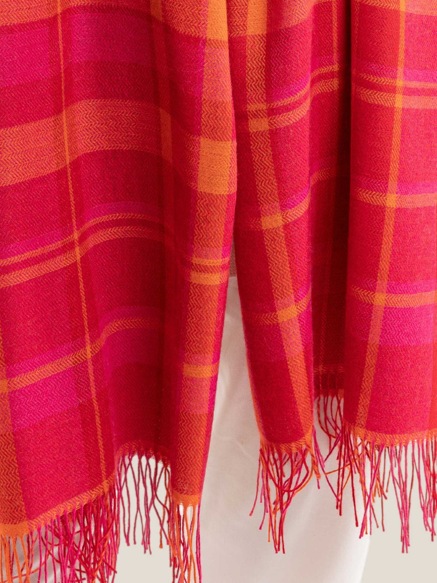 Close-up of fuchsia, red and yellow plaid baby alpaca shawl – large-scale plaid weave with fringed ends | Orange Inca