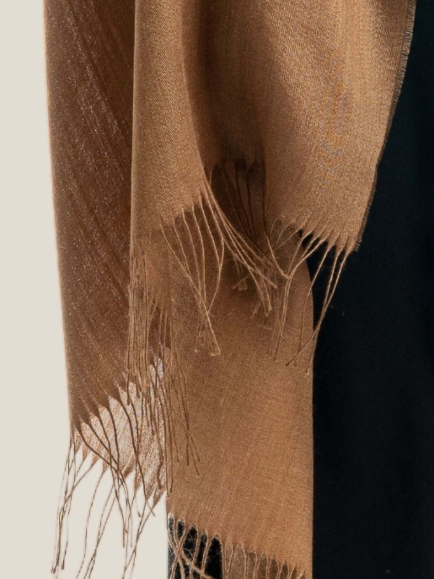 Close-up of soft alpaca wool shawl showing luxurious light fibre texture in camel brown