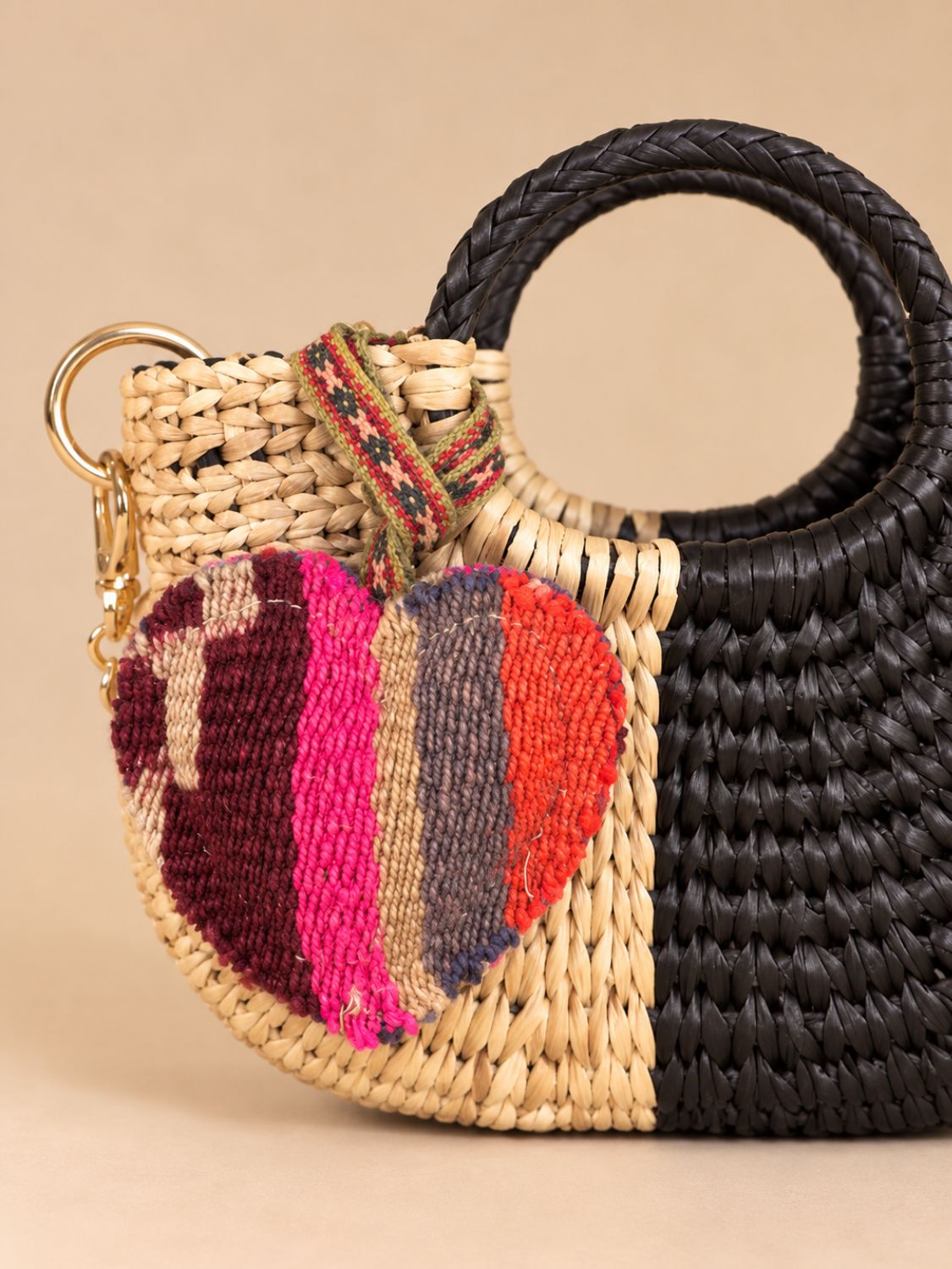 Medium heart wool charm hanging from a natural and black straw bag with a gold ring | Tasselita by Orange Inca