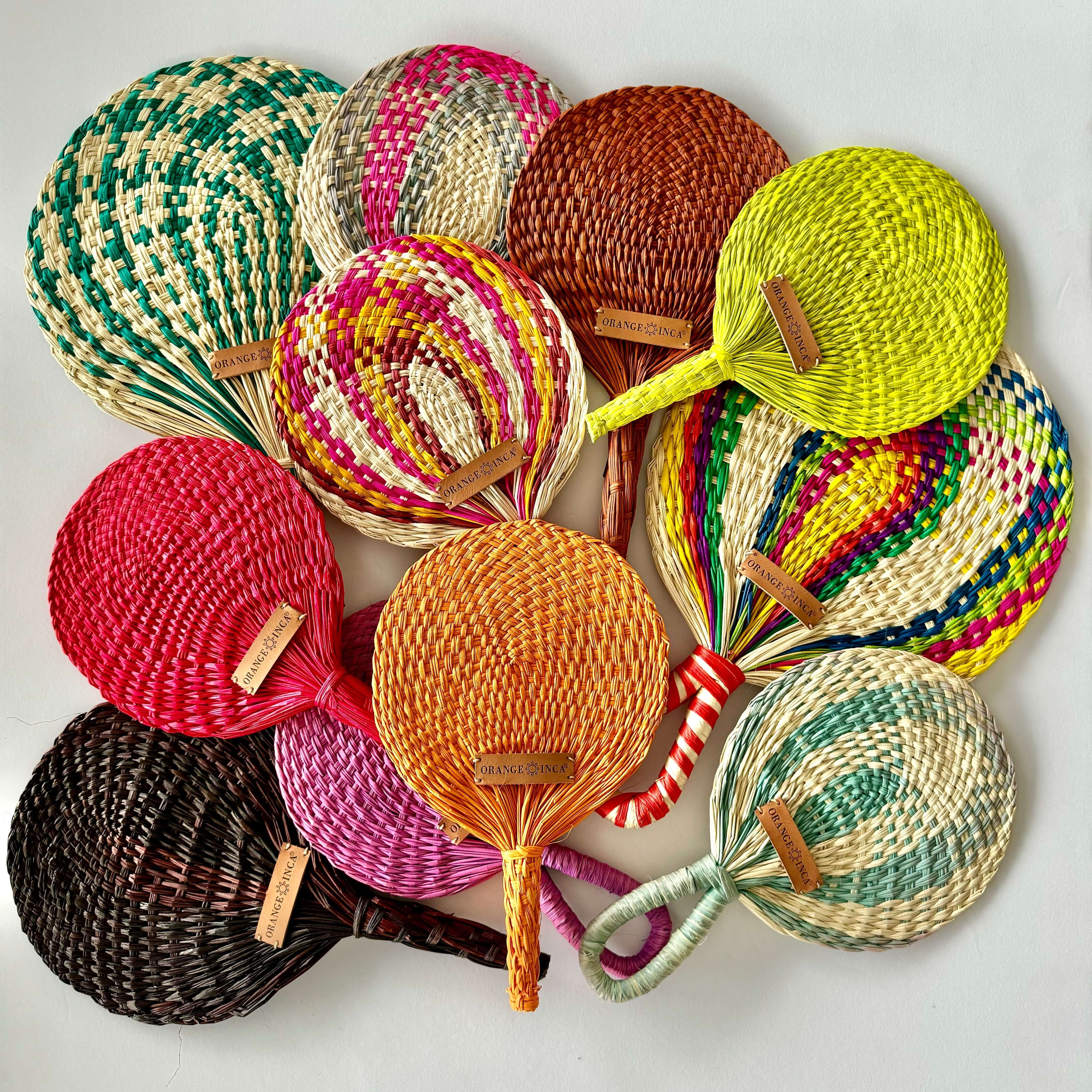 Handwoven straw fan showing natural reed texture and sustainable artisan craftsmanship in earthy and vibrant tones