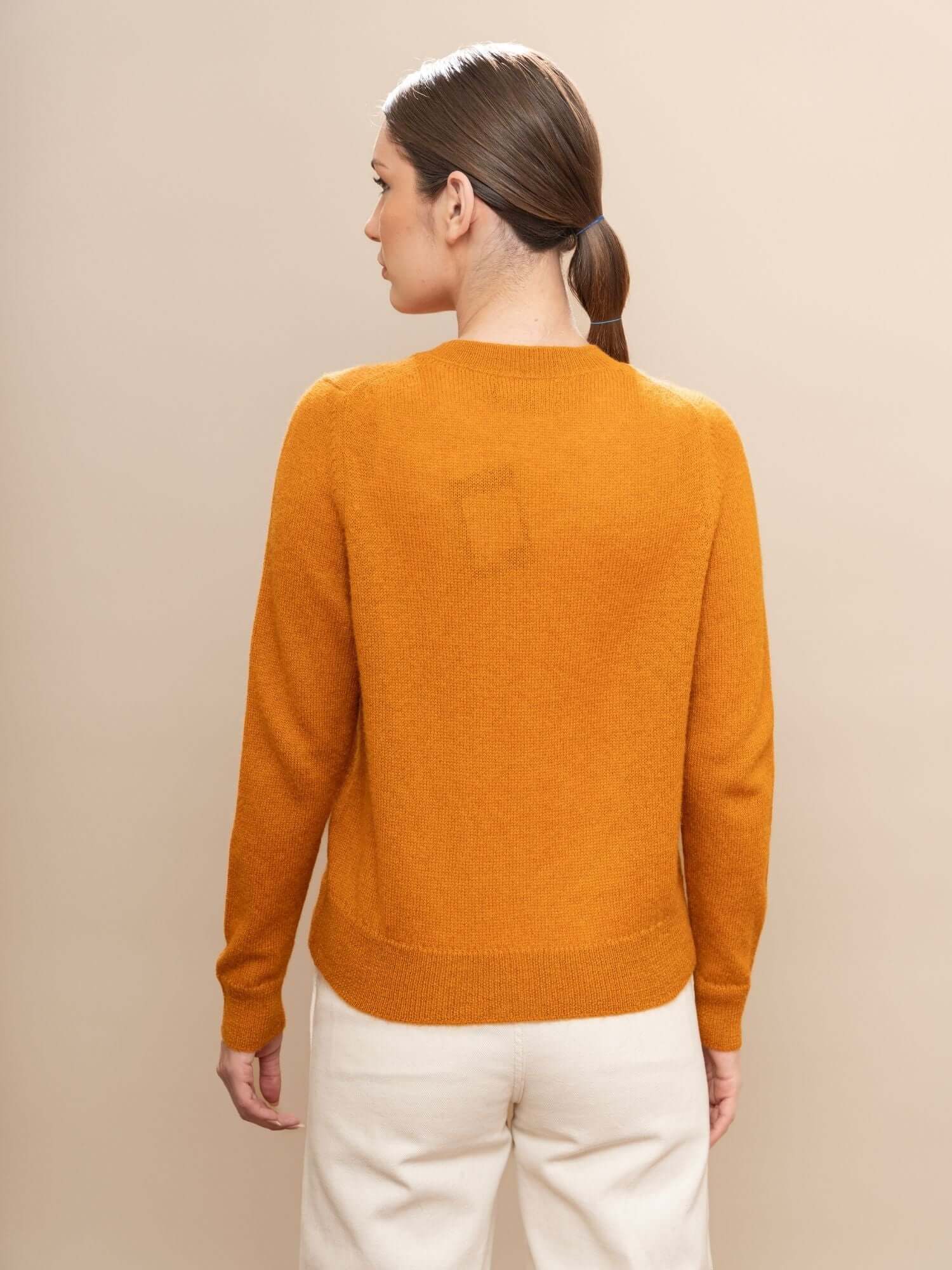 Back angle of turmeric alpaca jumper highlighting clean lines