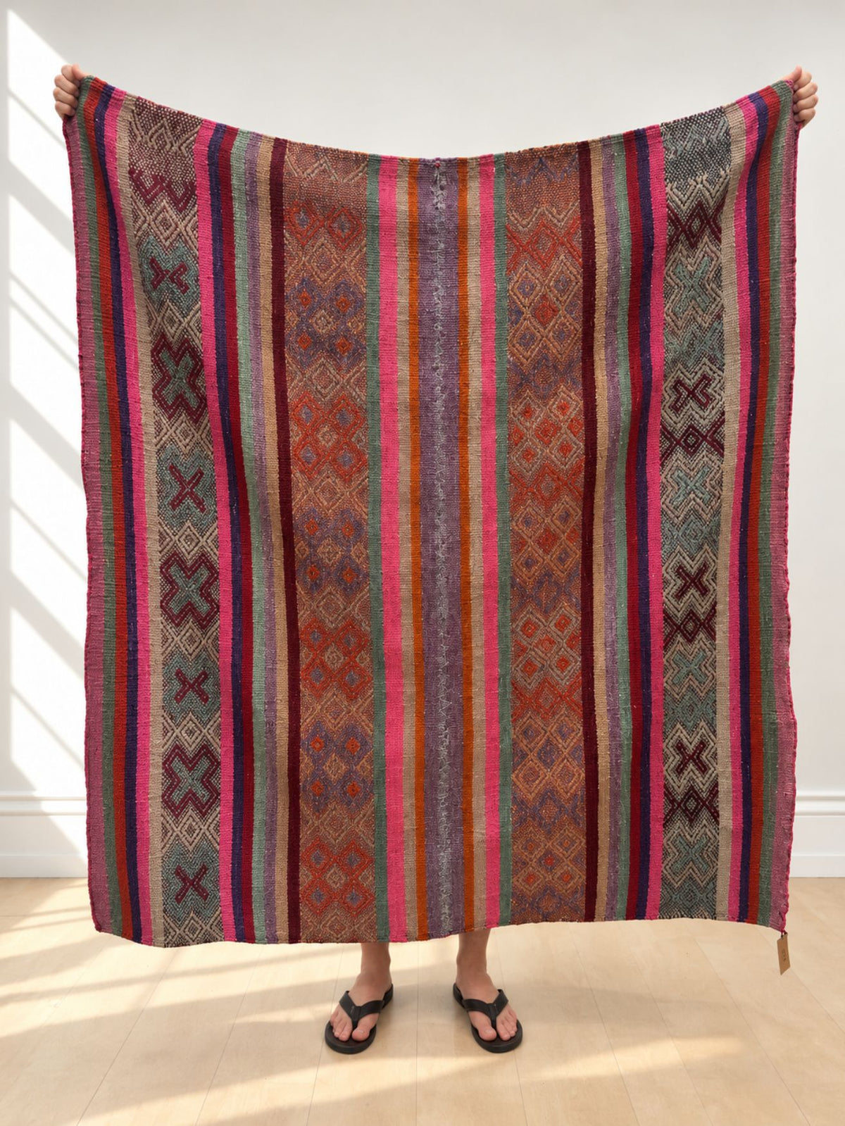 Vintage frazada rug No. 8 held up in full — magenta, teal, purple and orange stripes with diamond and cross bands, handwoven Peruvian sheep and alpaca wool, 160 × 150 cm | Orange Inca