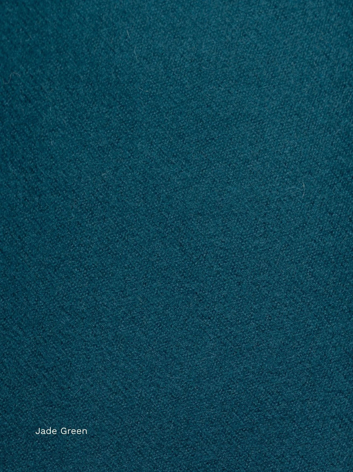 Close-up of a jade green naturally dyed baby alpaca scarf, deep teal soft woven fabric