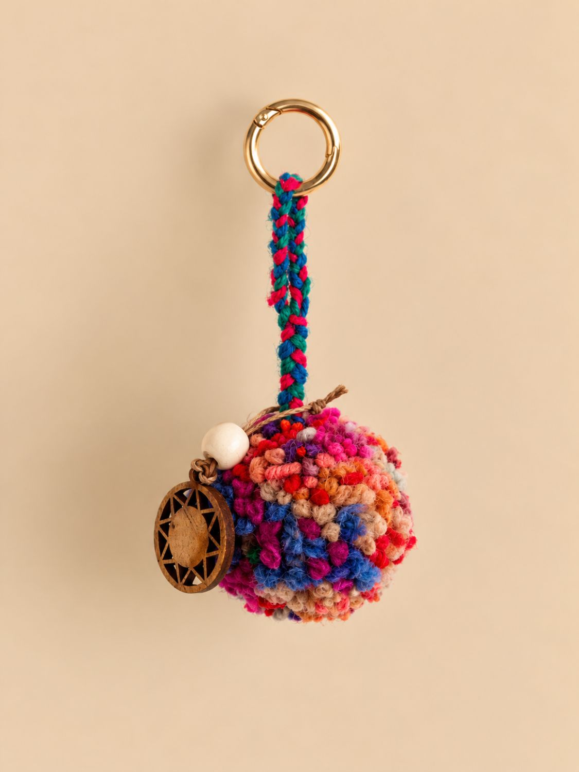 Multicolour wool pom-pom bag charm with a light gold ring, braided cord, white wooden bead and wooden sun charm | Tasselita by Orange Inca