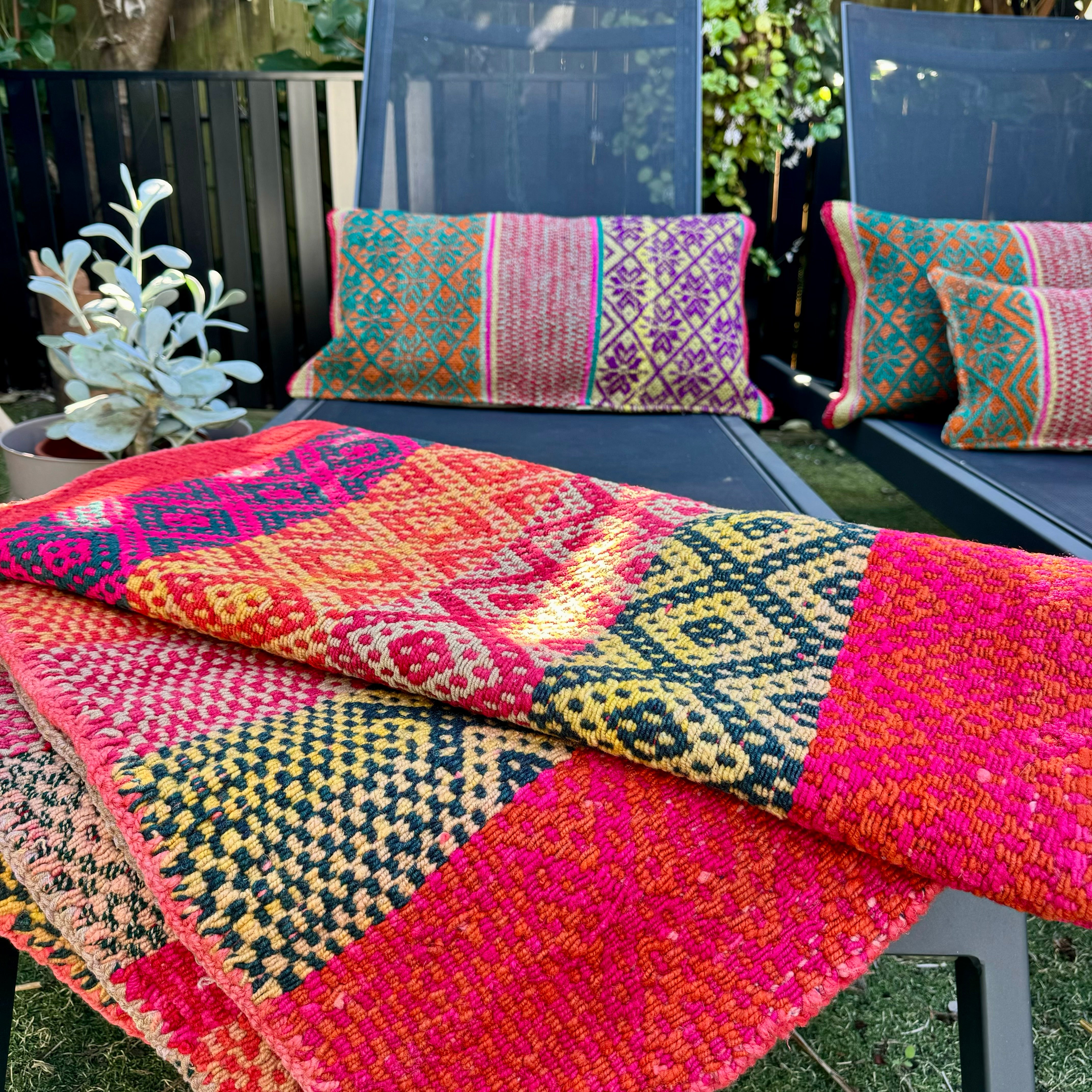 Beautiful Signature Peruvian Frazada on a sunbed, in a tropical garden. A beautiful setting to brighten up those neutral charcoal sunloungers. And how beautiful are they when surrounded by greens!