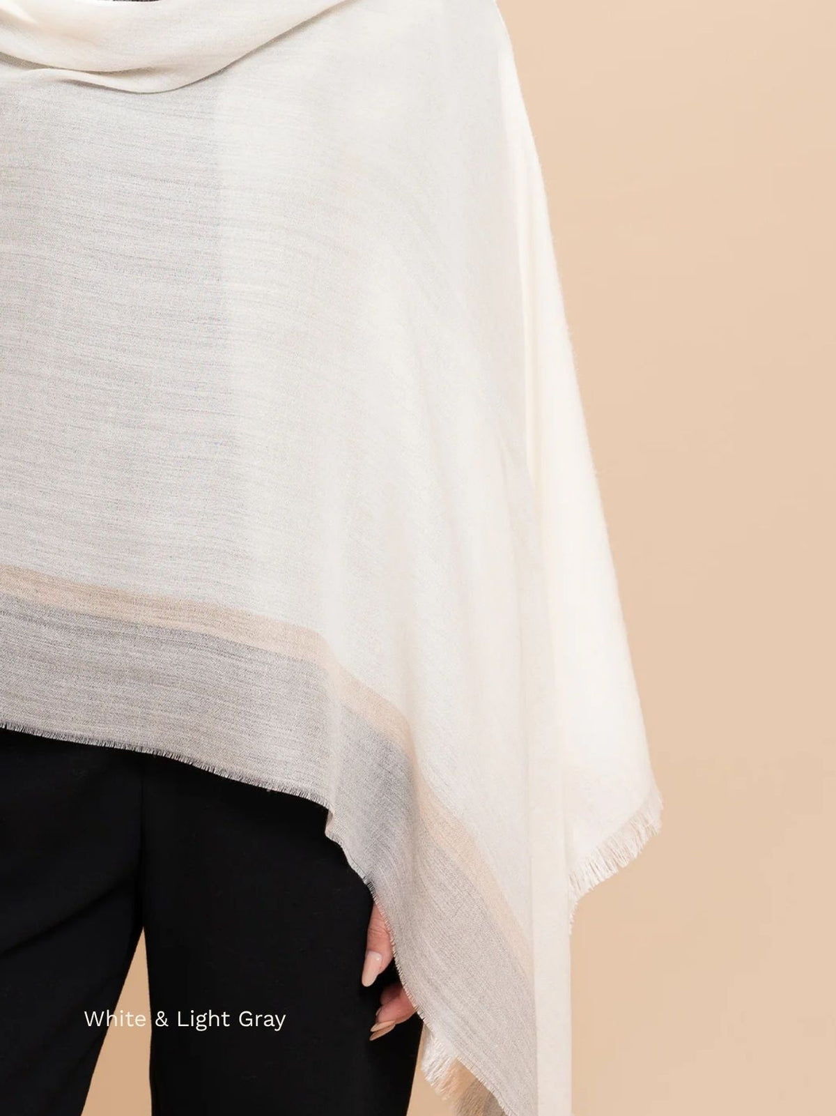 White and light grey silk baby alpaca blend shawl draped over the shoulder with a grey and beige border