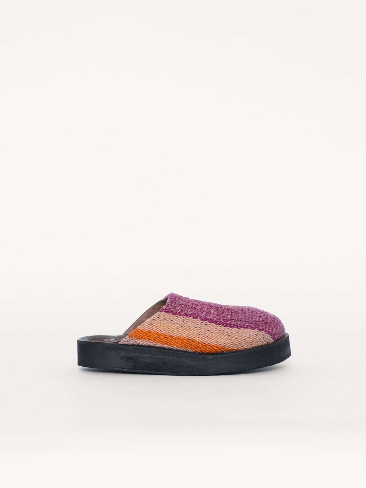 Washed pink leather clogs shoes for women and men with handwoven wool details, side view.