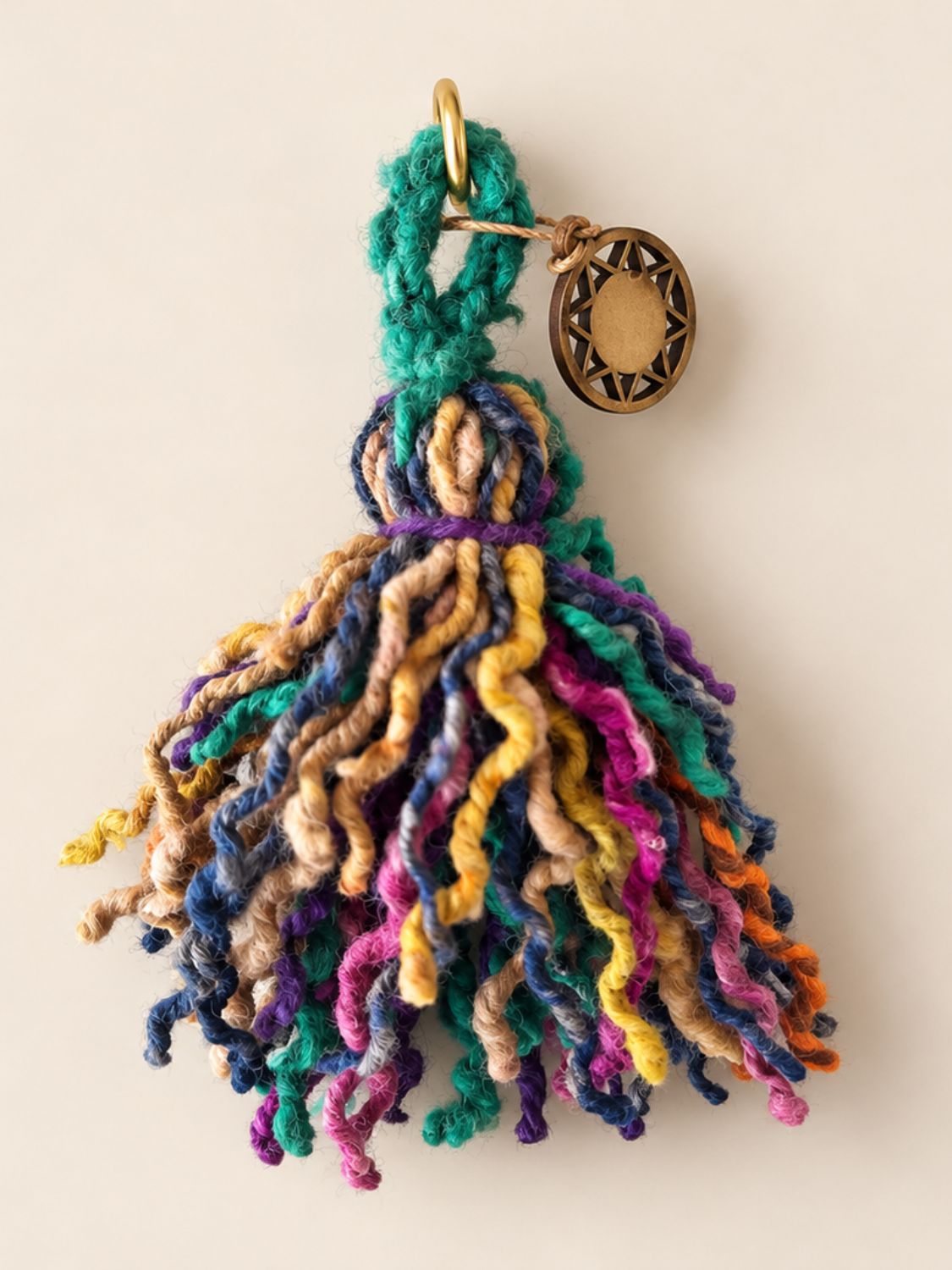 Mini wool tassel in washed blue, green and yellow with a light gold ring and a wooden Orange Inca sun charm | Tasselita by Orange Inca