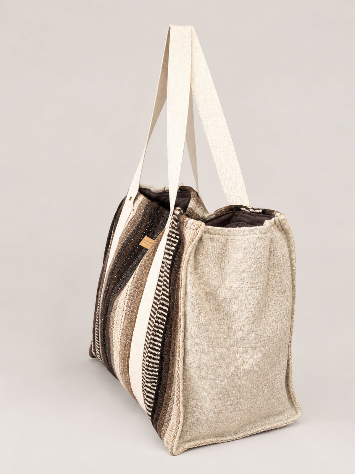 The Manta Carryall in Dark Browns and Ivory — side view, showing the ivory wool side