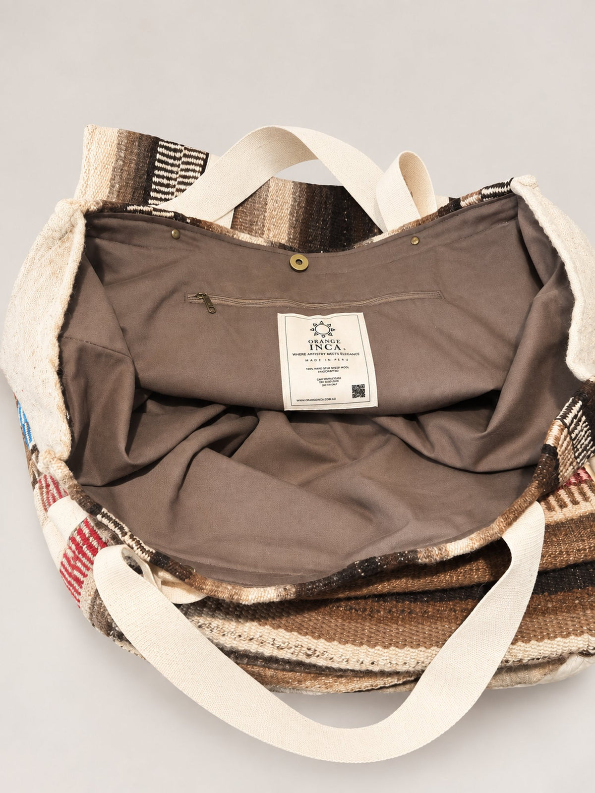 The Manta Carryall in Dark Browns and Ivory — inside: lining, magnetic snap closure and zip pocket