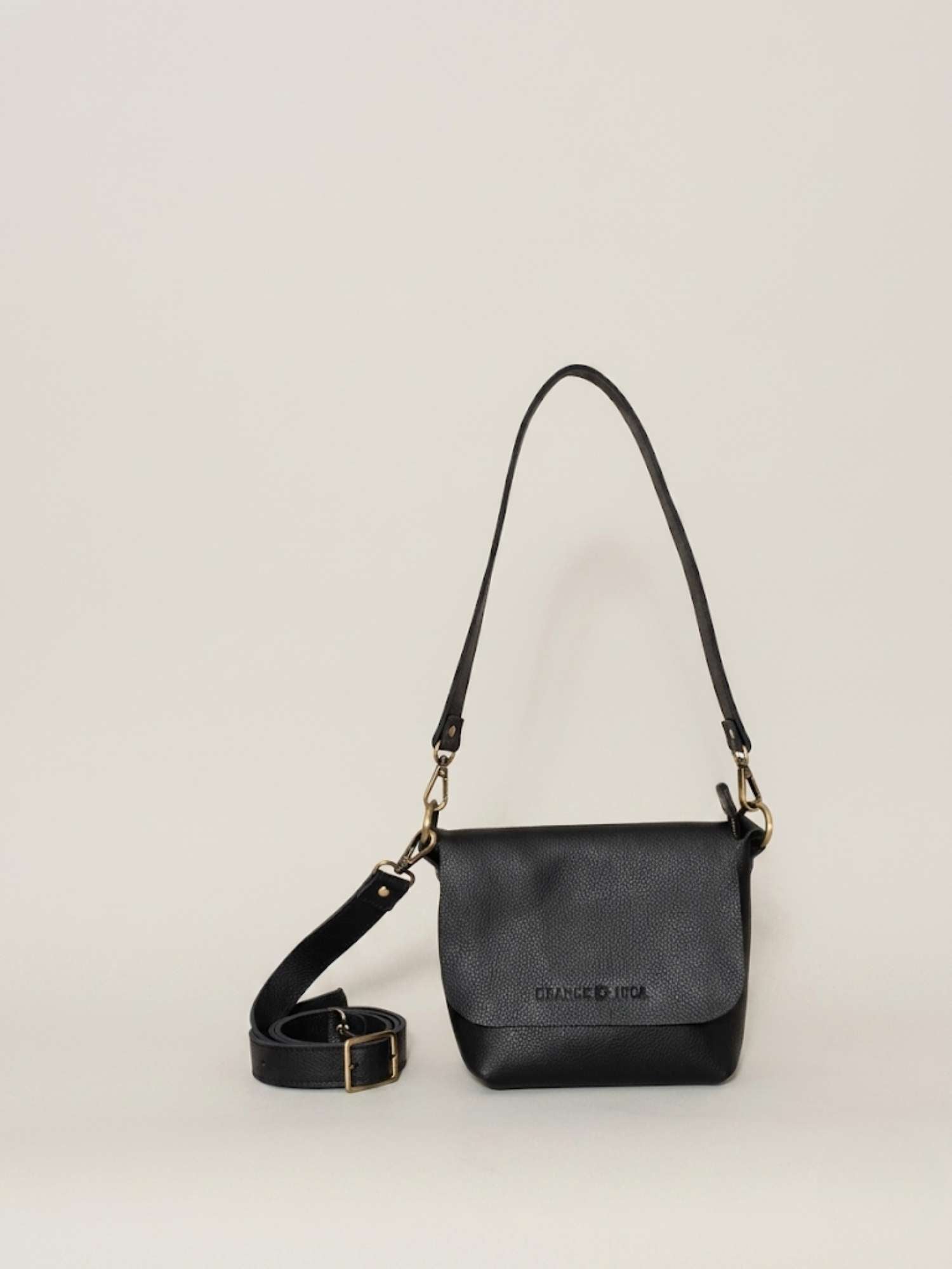 Black full-grain leather crossbody by Orange Inca — front with strap coiled | Orange Inca