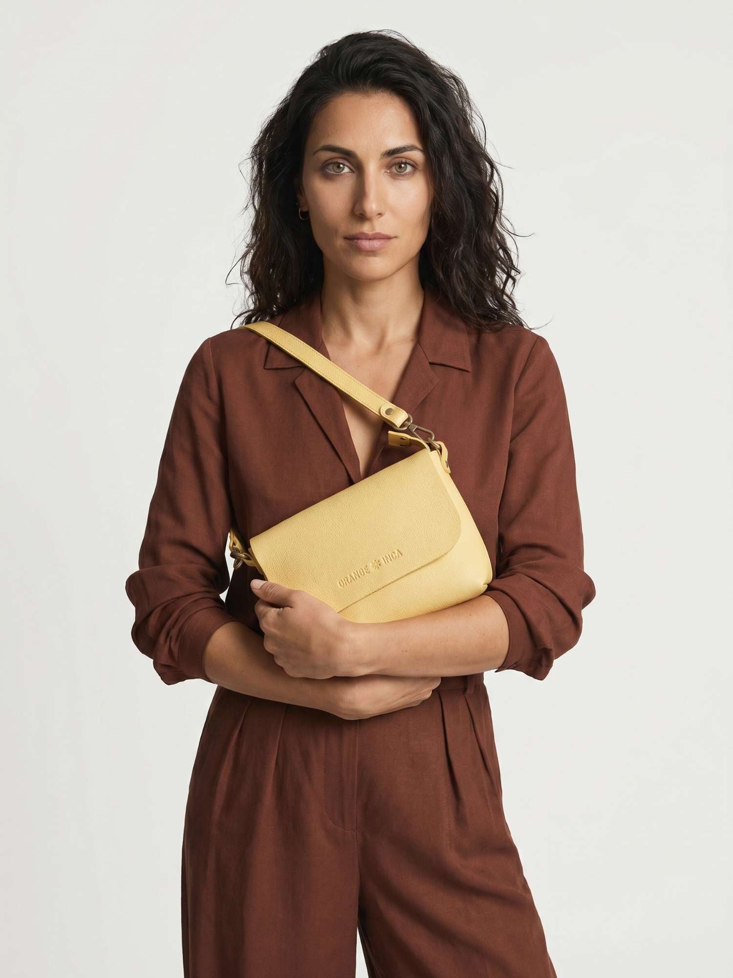 The Olivia Butter Yellow leather crossbody bag worn over the shoulder with the short strap — full-grain leather | Orange Inca