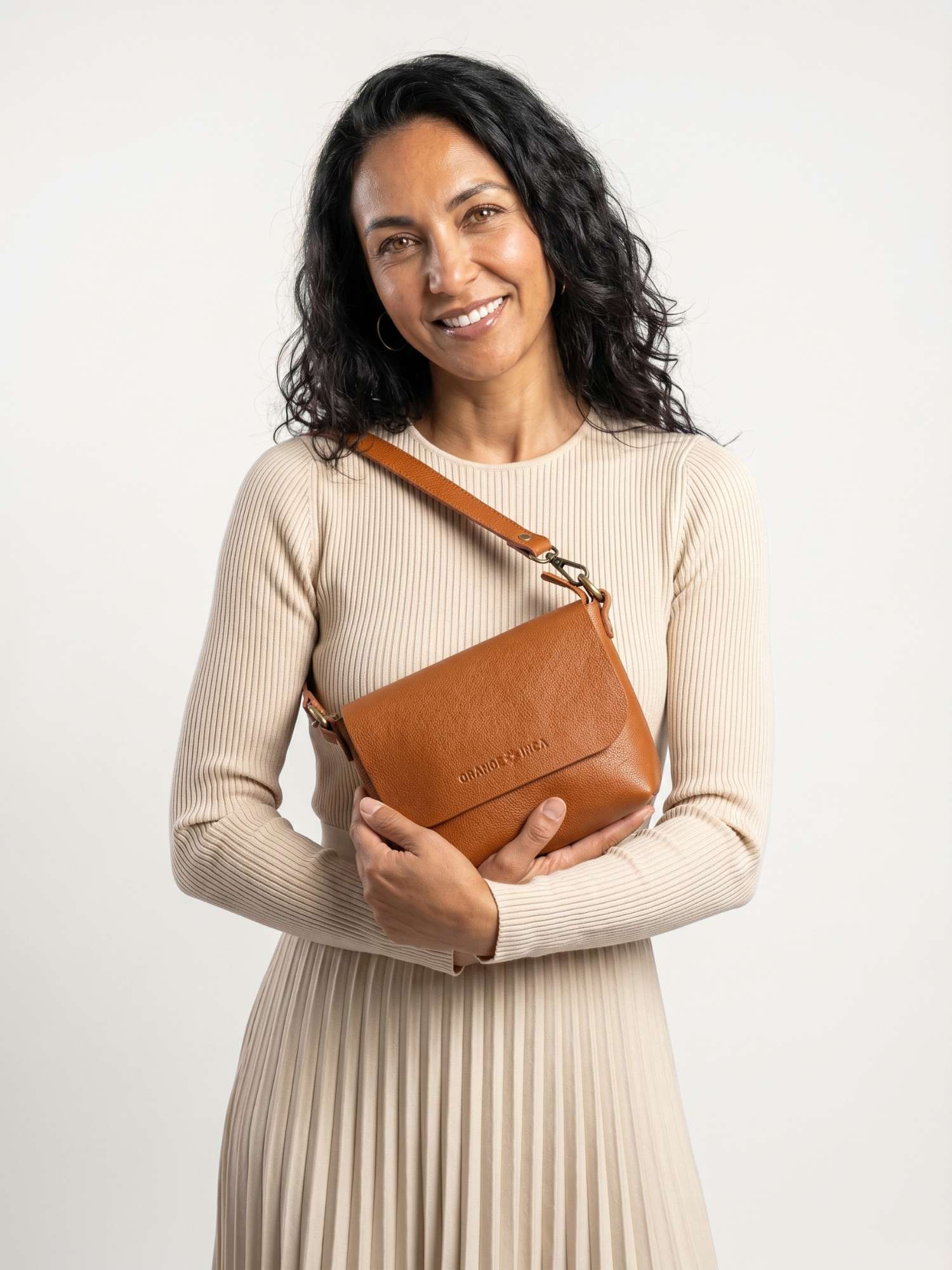 The Olivia Cognac leather crossbody bag worn over the shoulder with the short strap — full-grain leather | Orange Inca