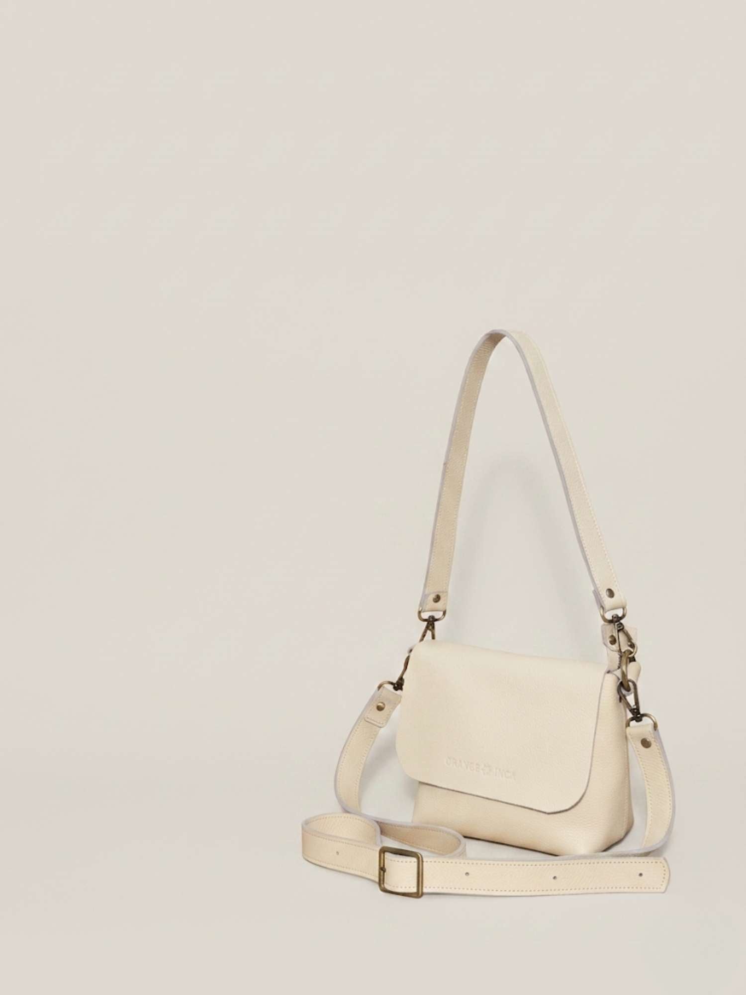 The Olivia Ivory leather crossbody — both straps shown (shoulder + crossbody), antique brass hardware | Orange Inca