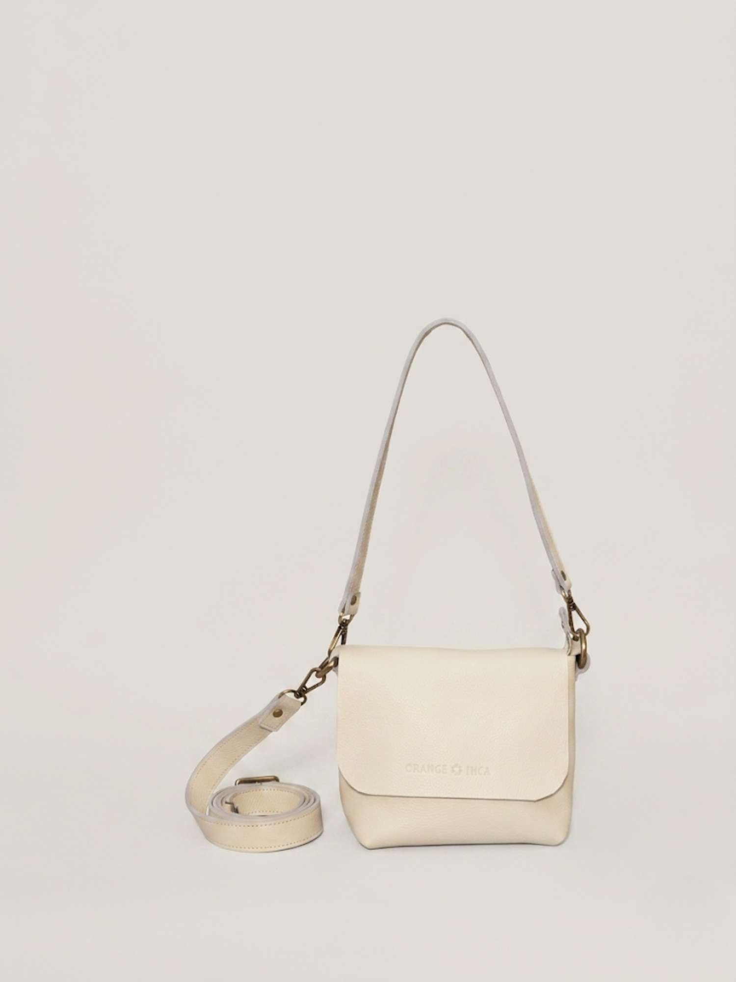 Ivory full-grain leather crossbody by Orange Inca — front with strap coiled | Orange Inca