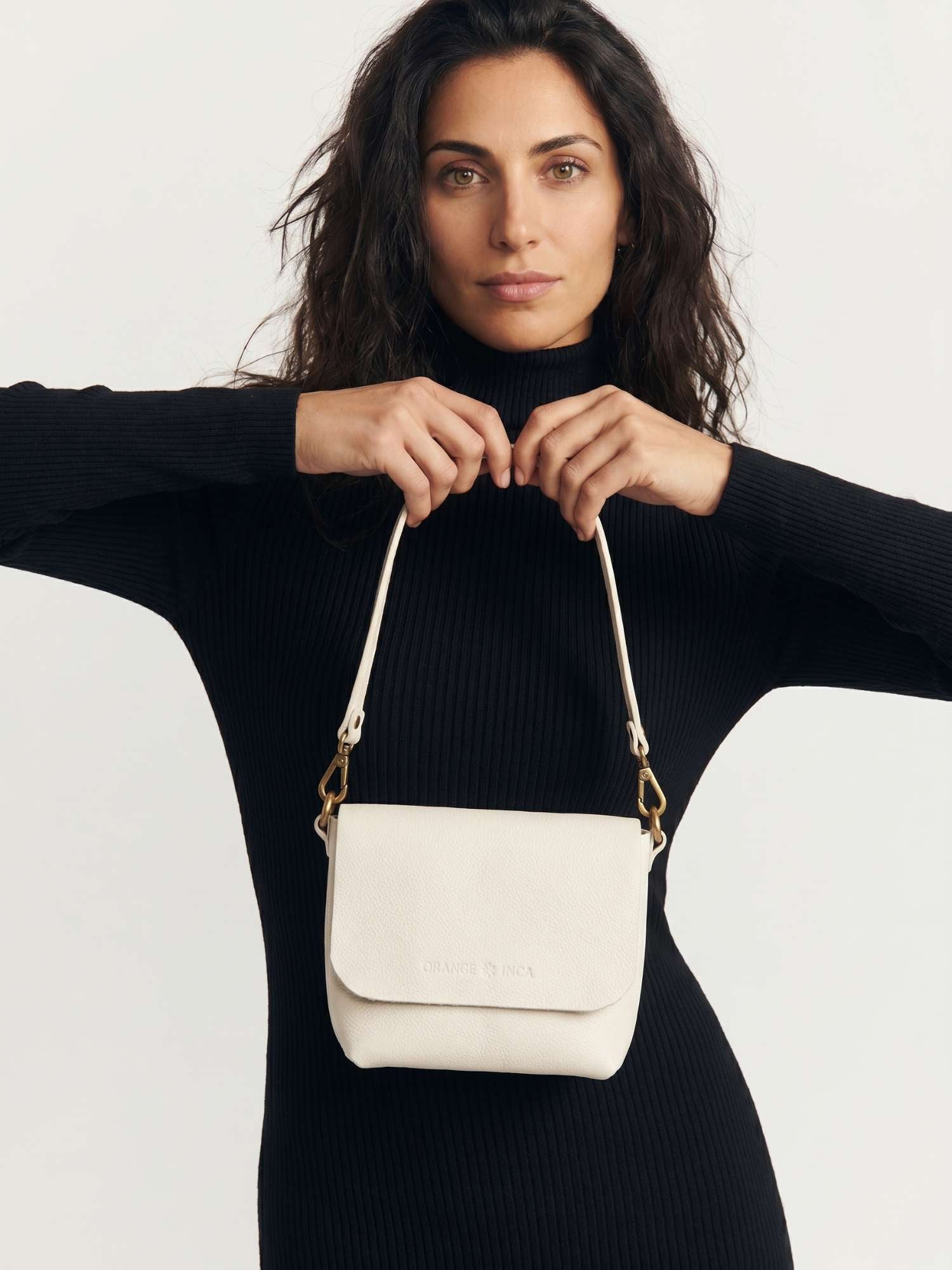 The Olivia Ivory leather crossbody bag worn over the shoulder with the short strap — full-grain leather | Orange Inca