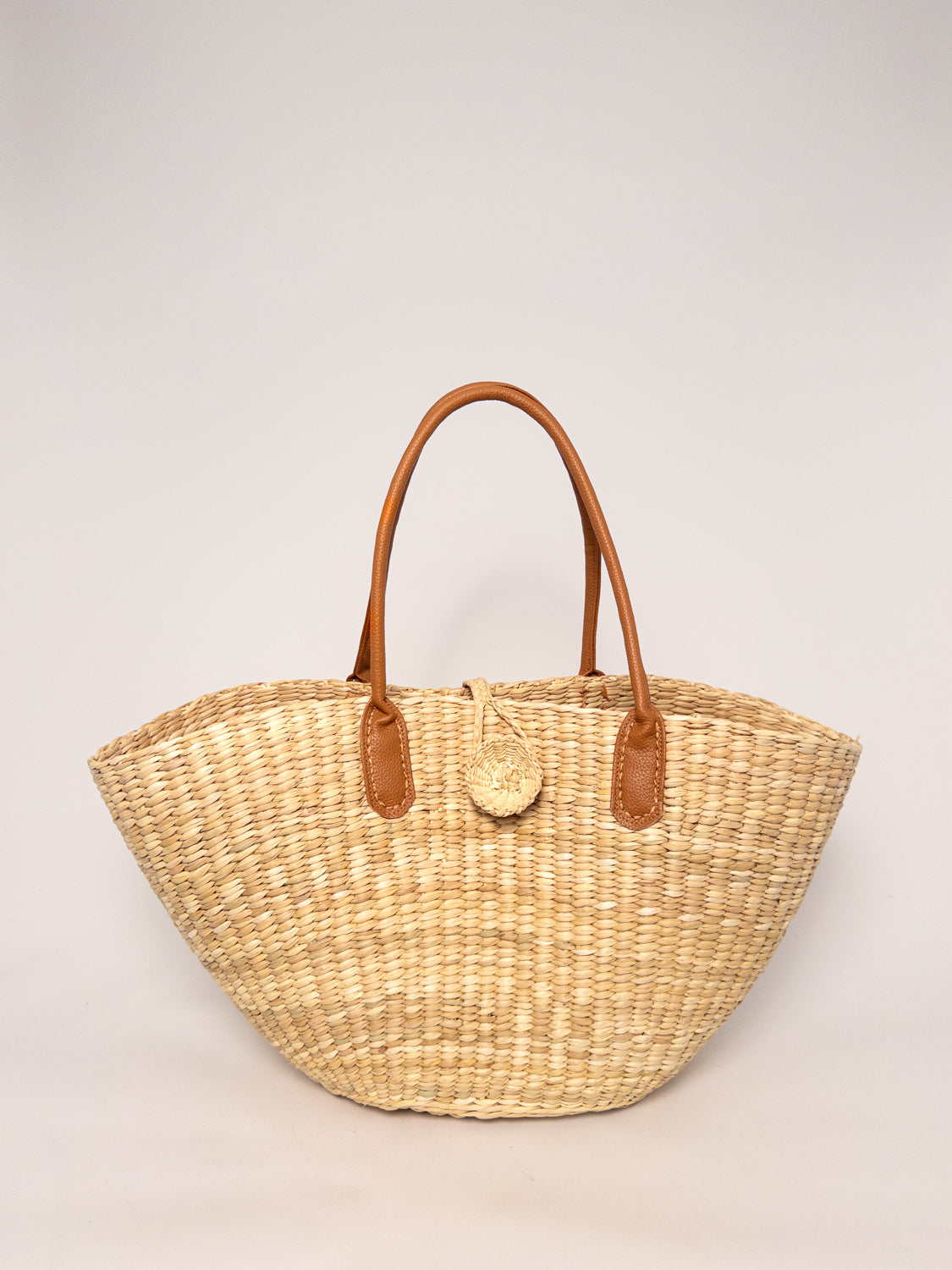 Playa Tote - Natural, handwoven junco tote bag with faux leather straps, natural dyes, and structured design.