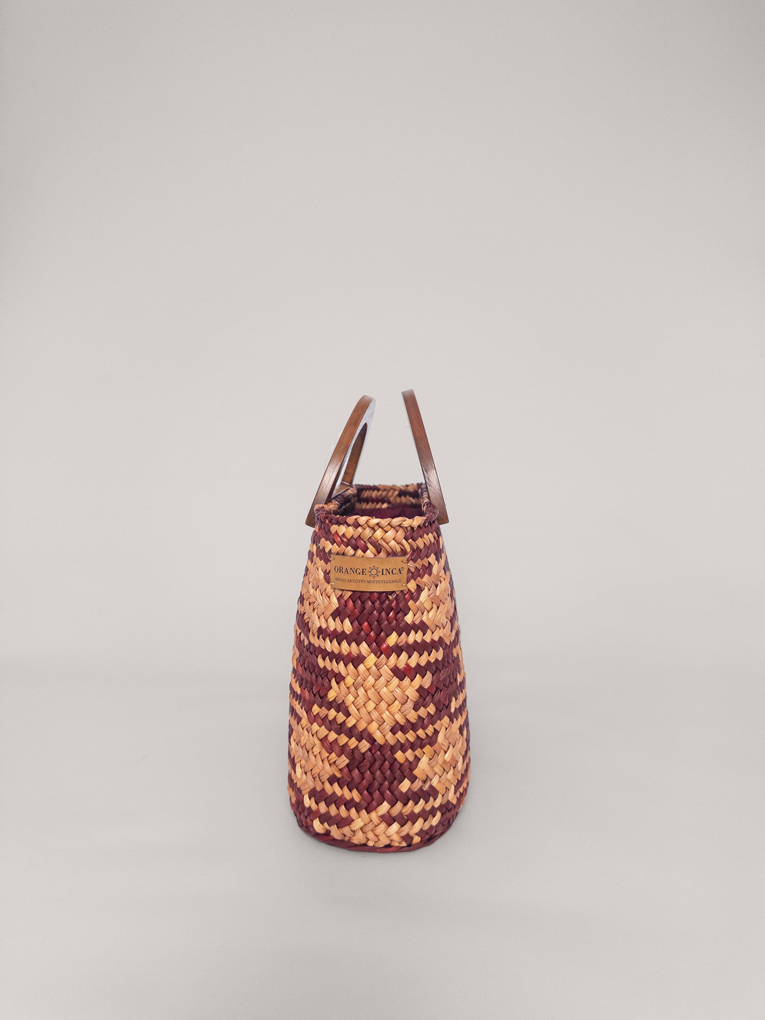 The Sophia bag in camel and beige, handwoven design with solid wood handles and internal drawstring closure.