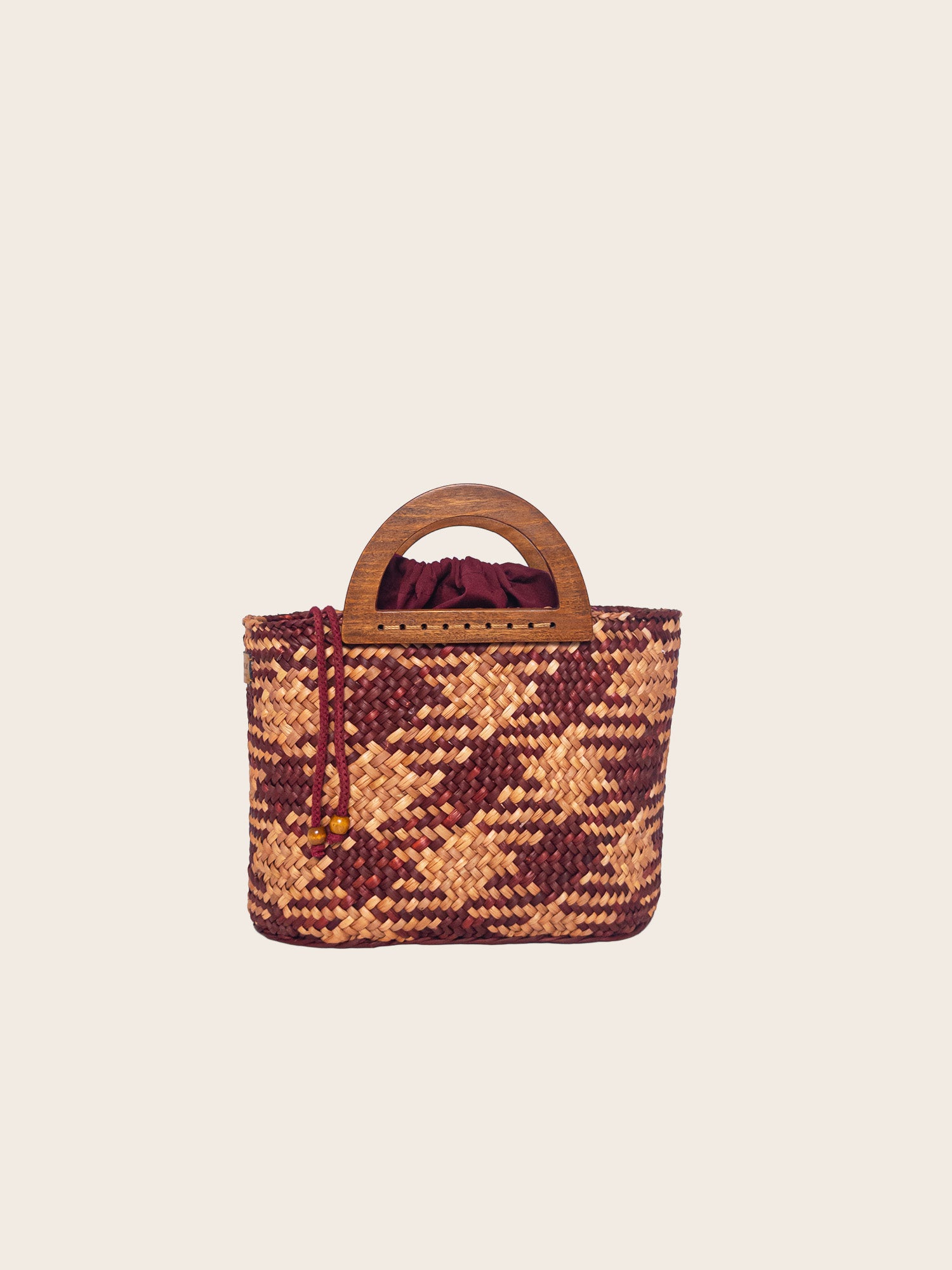 The Sophia bag in camel and beige, handwoven with natural dyes, featuring a wooden handle and drawstring closure.
