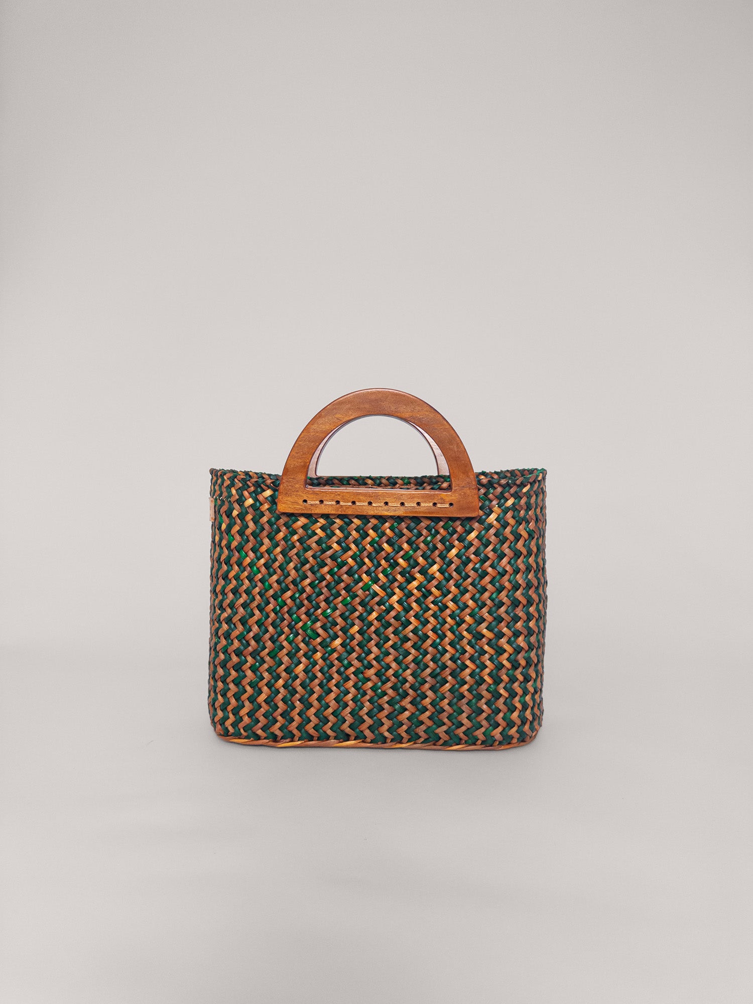 The Sophia bag in olive green and camel, handwoven with wooden handles, showcasing an earthy style and spacious interior.