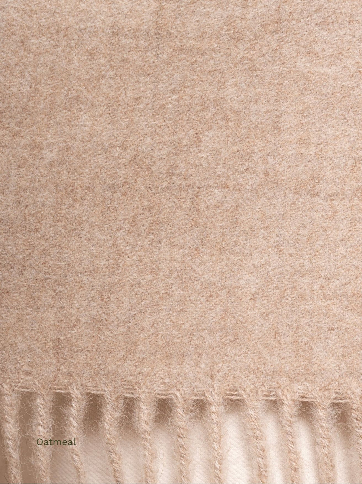Oatmeal undyed baby alpaca scarf, close-up of the soft light brown fabric and fringe